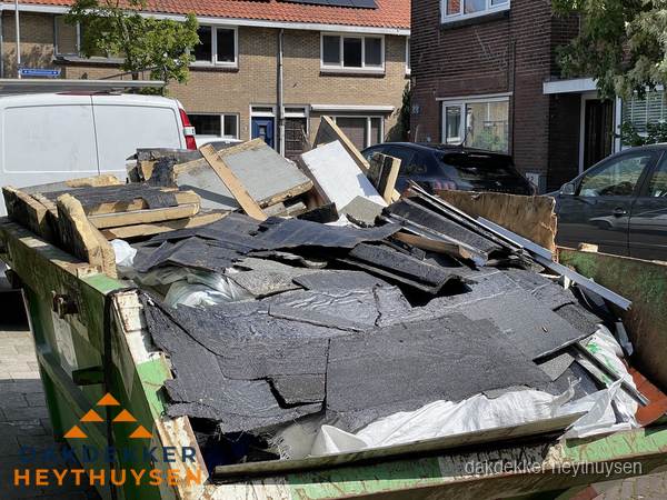 Afvalcontainer met gesloopt dakmateriaal tijdens dakkapel renovatie in Heythuysen Afvalcontainer met gesloopt dakmateriaal tijdens dakkapel renovatie in Heythuysen